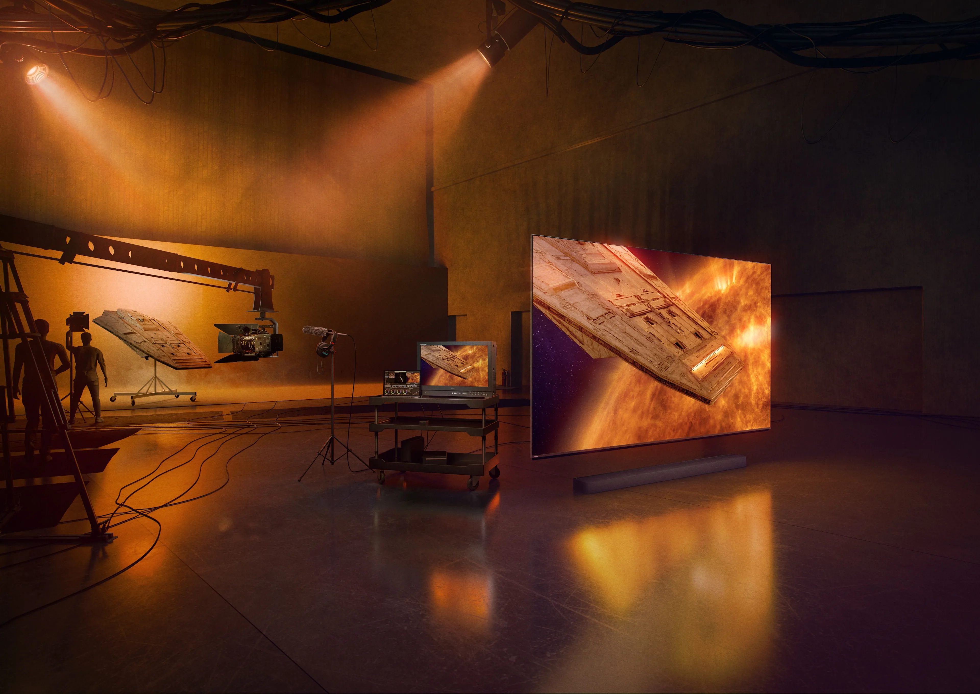 A film studio with spaceship models, cameras, and lighting equipment; a large screen displays a spaceship flying through space, matching a physical model suspended in the background.