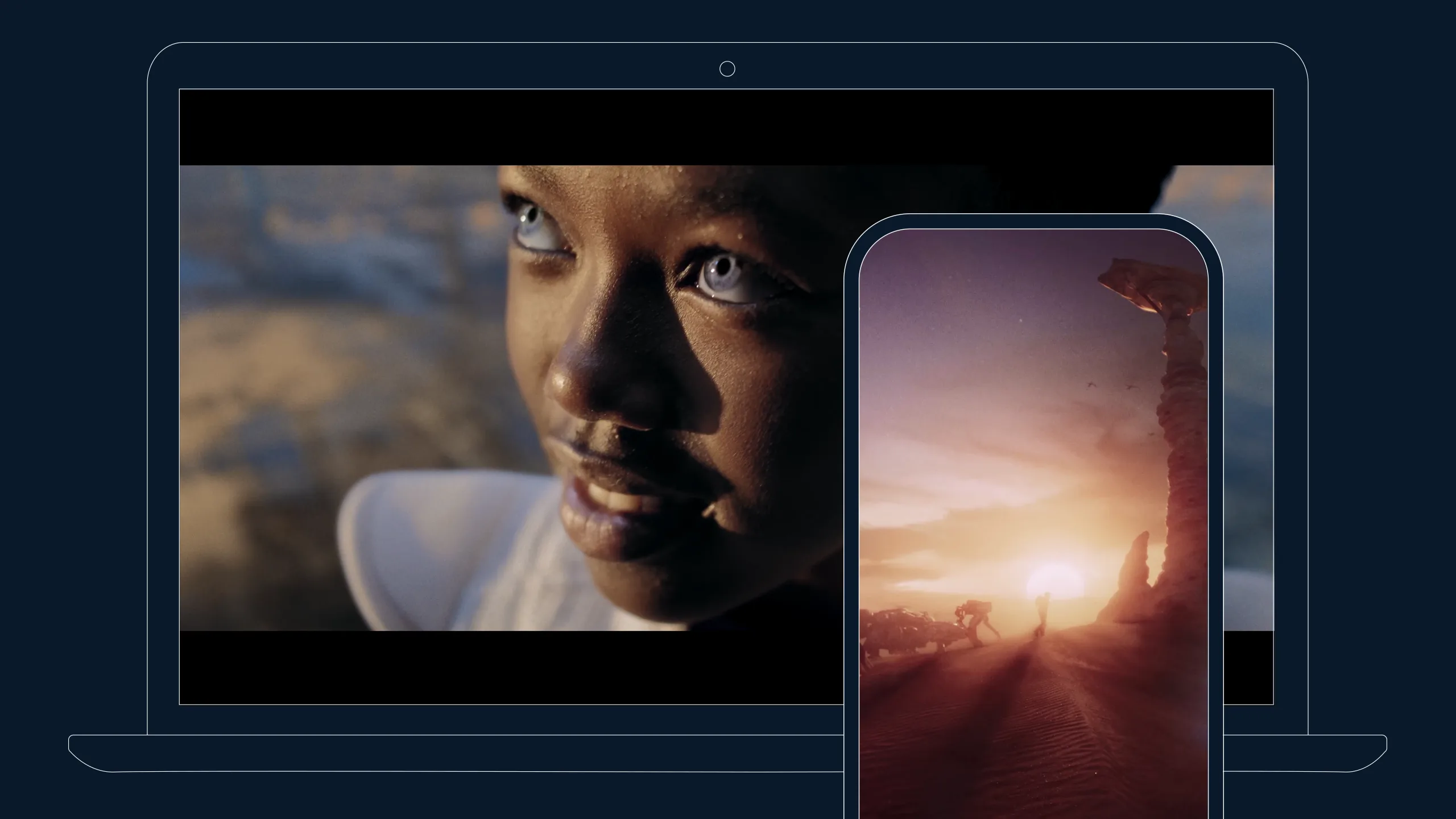 A close-up of a person with bright eyes on a laptop screen; in front, a smartphone displays a scene of a sunset in a desert landscape with rock formations.