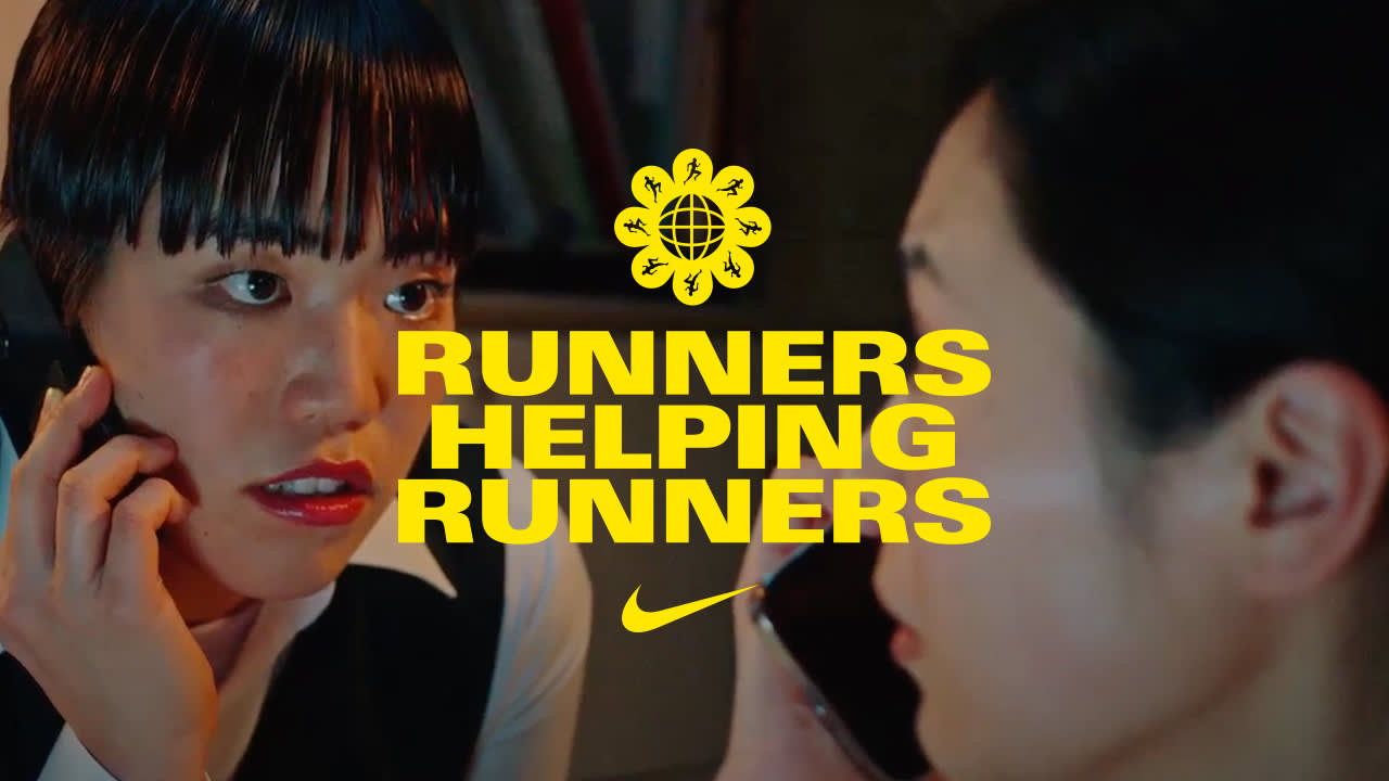 Two women are talking on phones, facing each other closely. Bright yellow text over the image reads RUNNERS HELPING RUNNERS with a Nike logo and a flower-like symbol above the text.