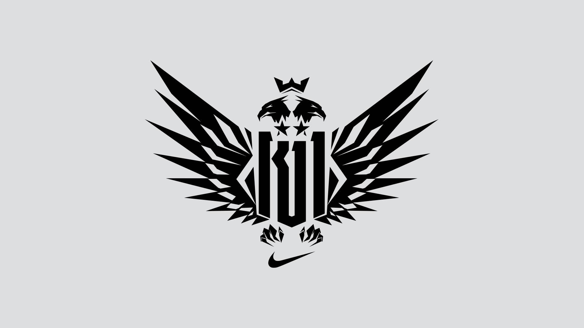 Black geometric eagle with spread wings, a crown above its head, three stars on its chest, and a stylized K body. Nike swoosh logo appears below the eagle, all on a light gray background.