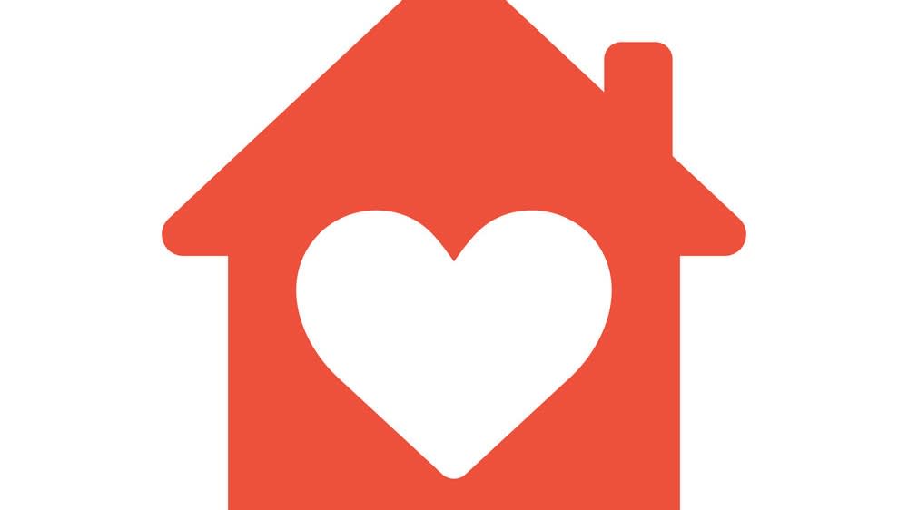 A red house icon with a white heart shape in the center, symbolizing love and warmth at home, on a plain white background.