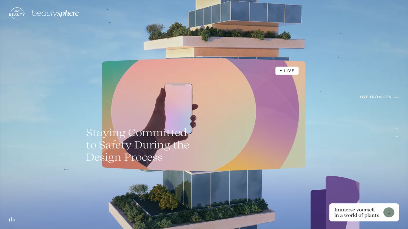 A futuristic building with stacked garden terraces, a large colorful screen showing a hand holding a phone, and the text “Staying Committed to Safety During the Design Process.” Blue sky and plants surround the scene.