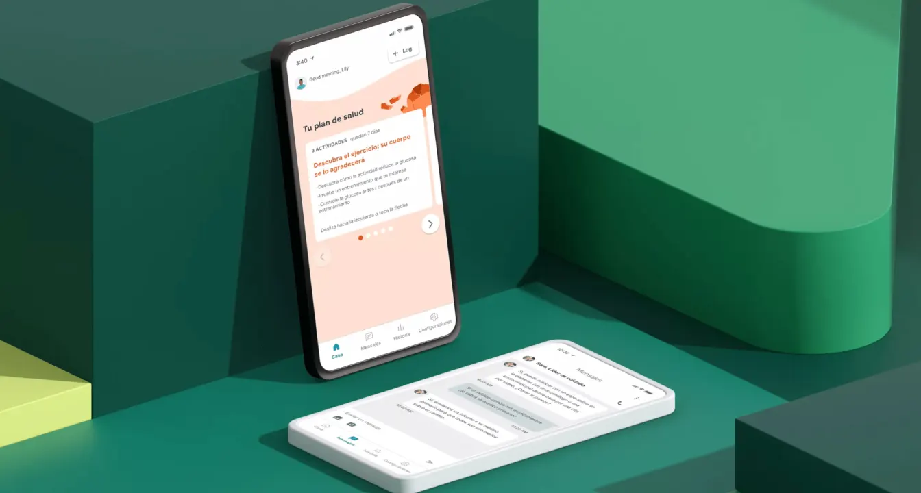 A smartphone displaying a Spanish-language health app screen is propped against green geometric blocks, with another phone laying flat nearby showing a chat interface. The background features shades of green and yellow.