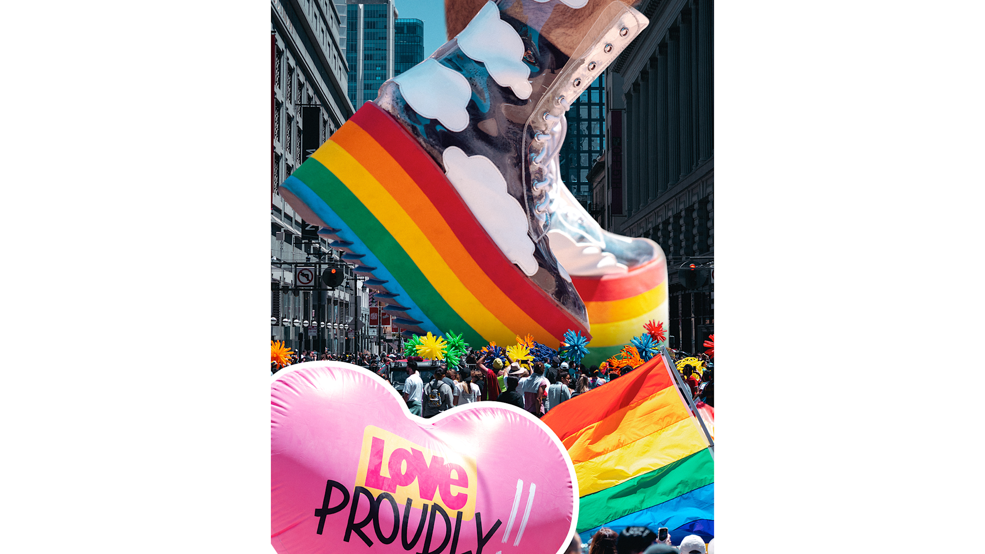 A giant inflatable boot with rainbow stripes and clouds floats above a crowd at a Pride parade. People carry rainbow flags and a large pink heart-shaped balloon that says Love Proudly. Bright colors fill the lively street scene.