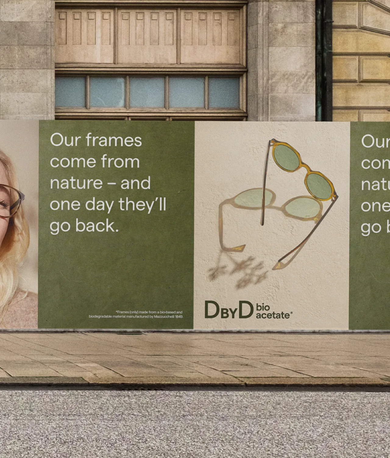 A street advertisement displays eco-friendly glasses, text stating, Our frames come from nature – and one day they’ll go back, and an illustration of glasses casting a shadow. Branding reads “DBYD bio acetate.”.