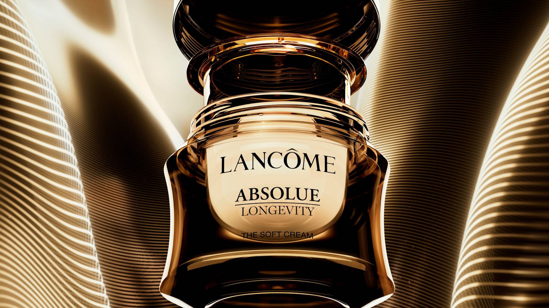 A luxurious jar of Lancôme Absolue Longevity The Soft Cream is centered against a golden, wavy, and illuminated background, highlighting the products elegant packaging and premium branding.