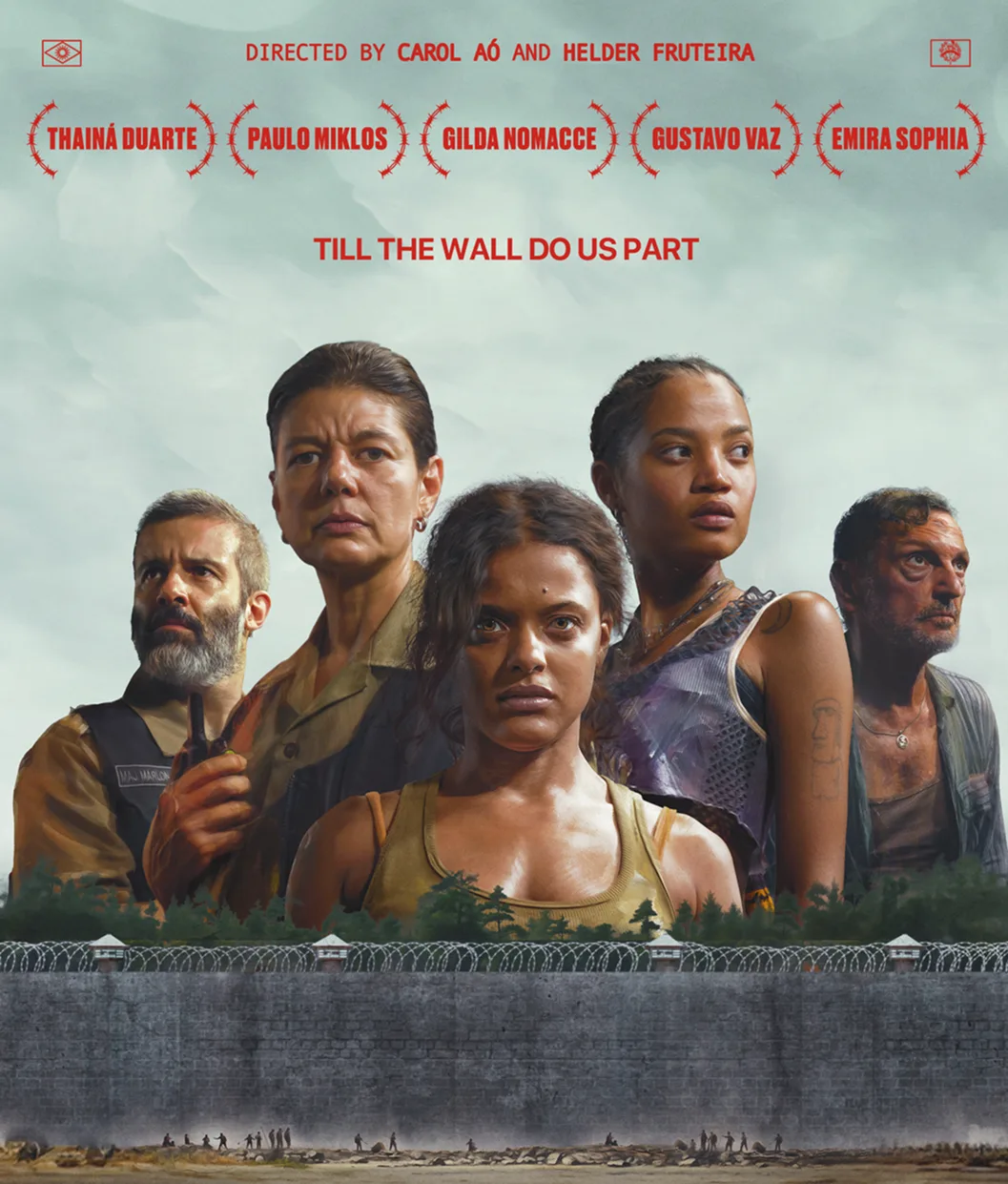 Five serious-looking people stand in front of a tall prison wall topped with barbed wire. The sky is cloudy and the film title, cast names, and credits appear above them in red text.