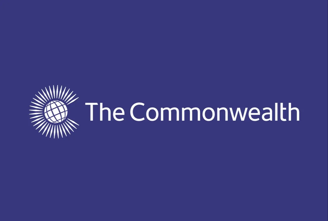 The Commonwealth logo with a globe surrounded by radiating lines on the left and the words The Commonwealth in white text on a purple background.