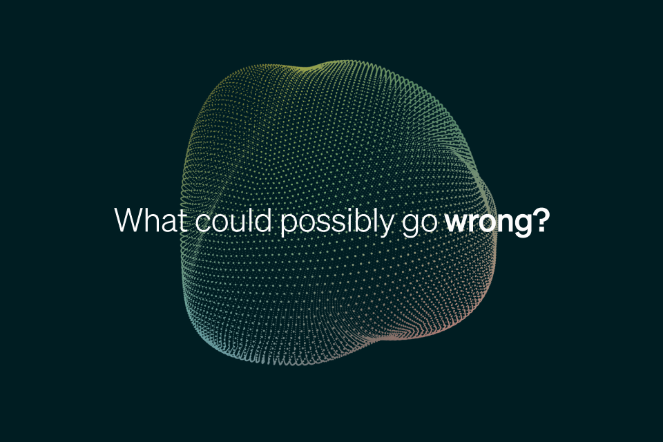 A digital abstract 3D sphere made of small dots with the text What could possibly go wrong? centered in front. The word wrong? is bolded. The background is dark green.