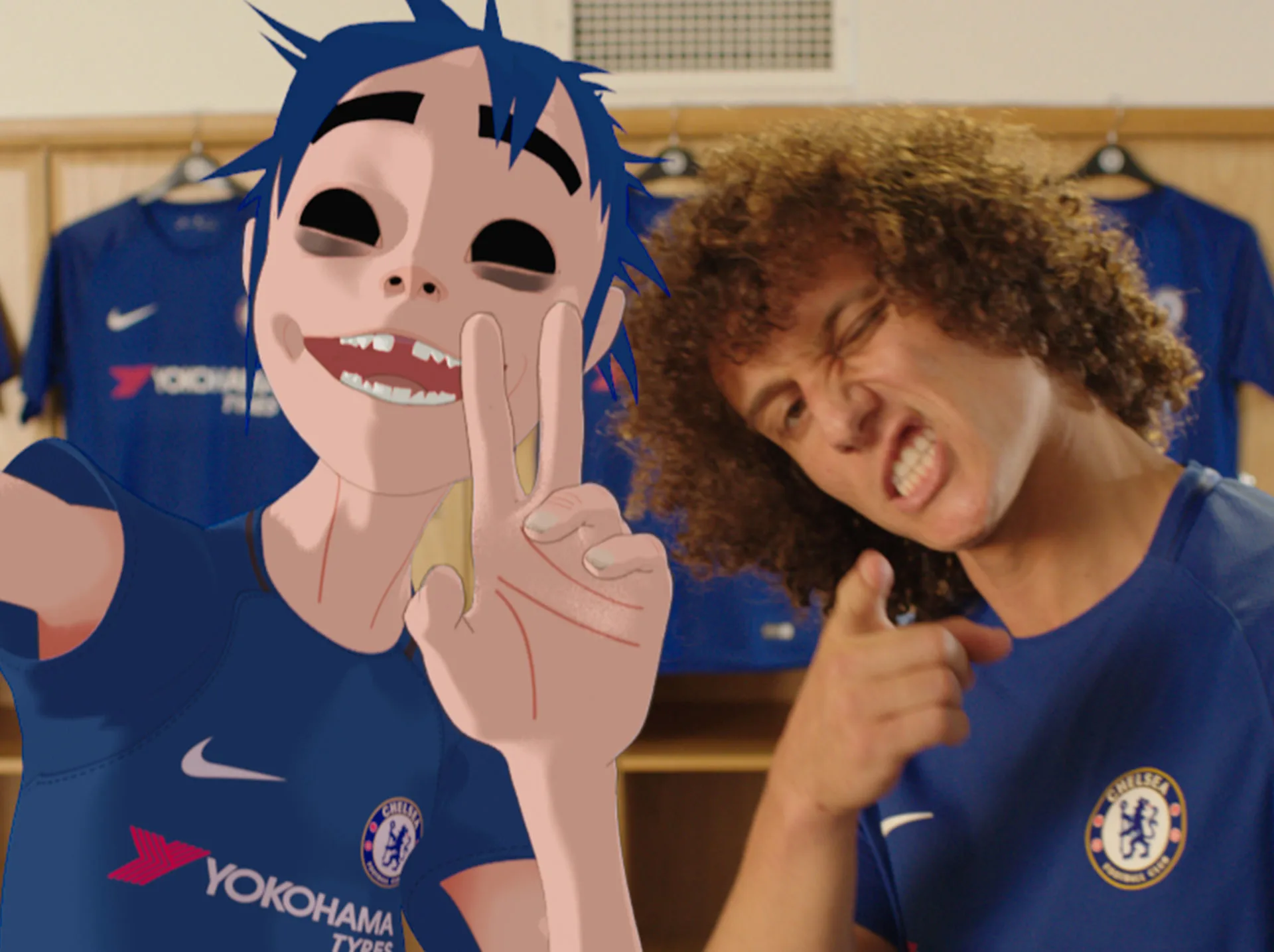 A cartoon character with blue hair takes a selfie with a soccer player in a Chelsea FC jersey, both making playful poses in a locker room with more Chelsea shirts hanging in the background.