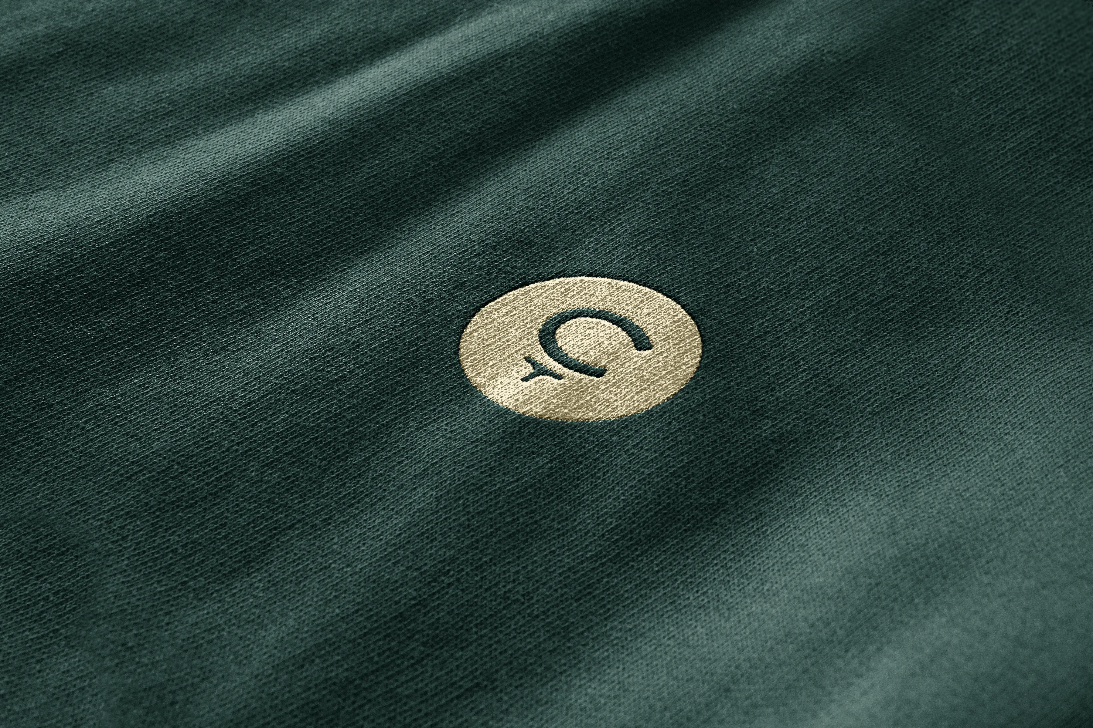 A green piece of fabric with a circular gold Cleeks Golf Club logo.