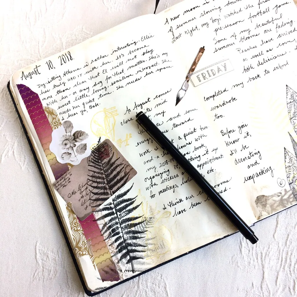 An open journal shows handwritten entries, decorative stickers, pressed leaves, and a pen resting on the pages. The date reads August 10, 2018, with creative notes and collaged paper elements filling the spread.