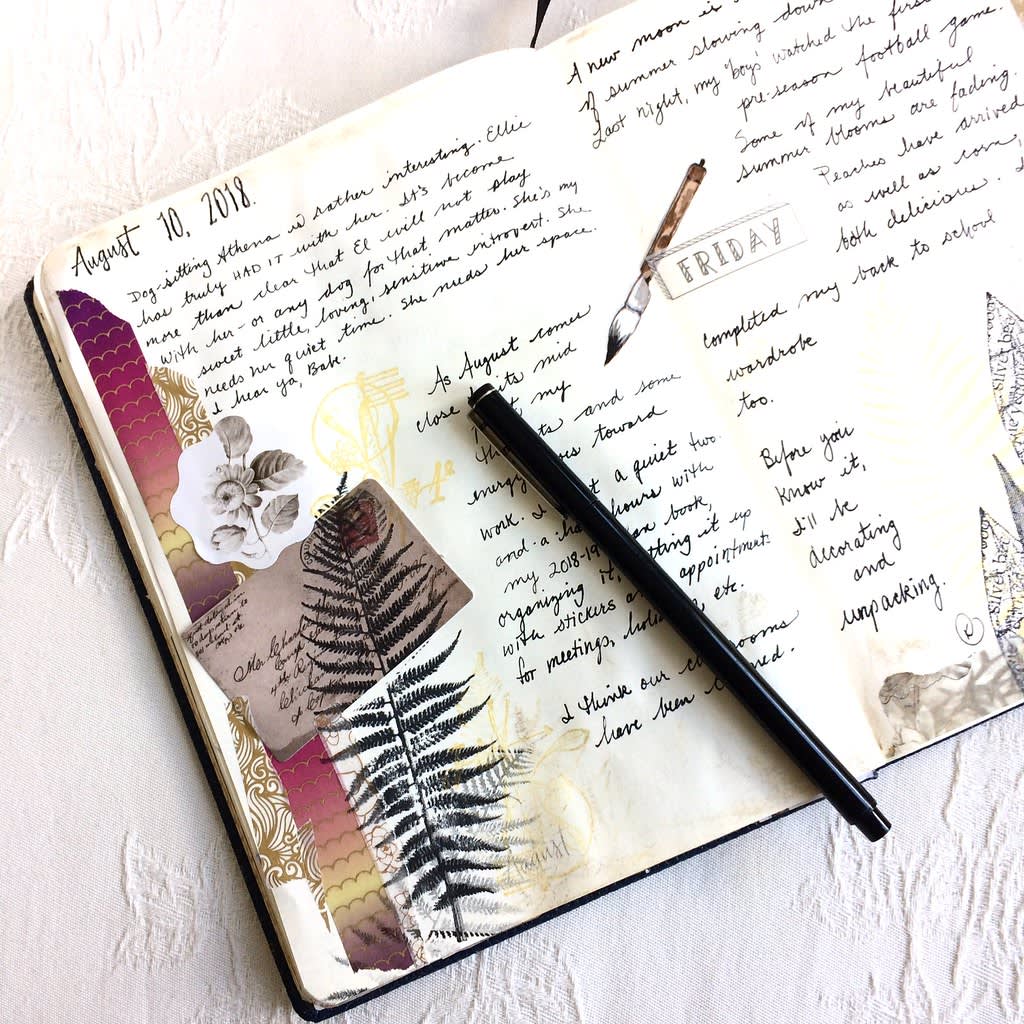 An open journal shows handwritten entries, decorative stickers, pressed leaves, and a pen resting on the pages. The date reads August 10, 2018, with creative notes and collaged paper elements filling the spread.