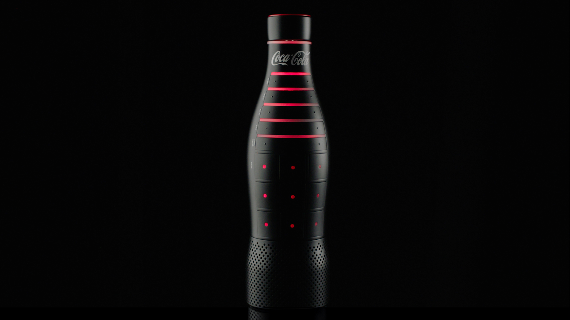 A sleek black Coca-Cola bottle with horizontal red LED light accents and small red dots, set against a black background. The bottle has a modern, futuristic design.