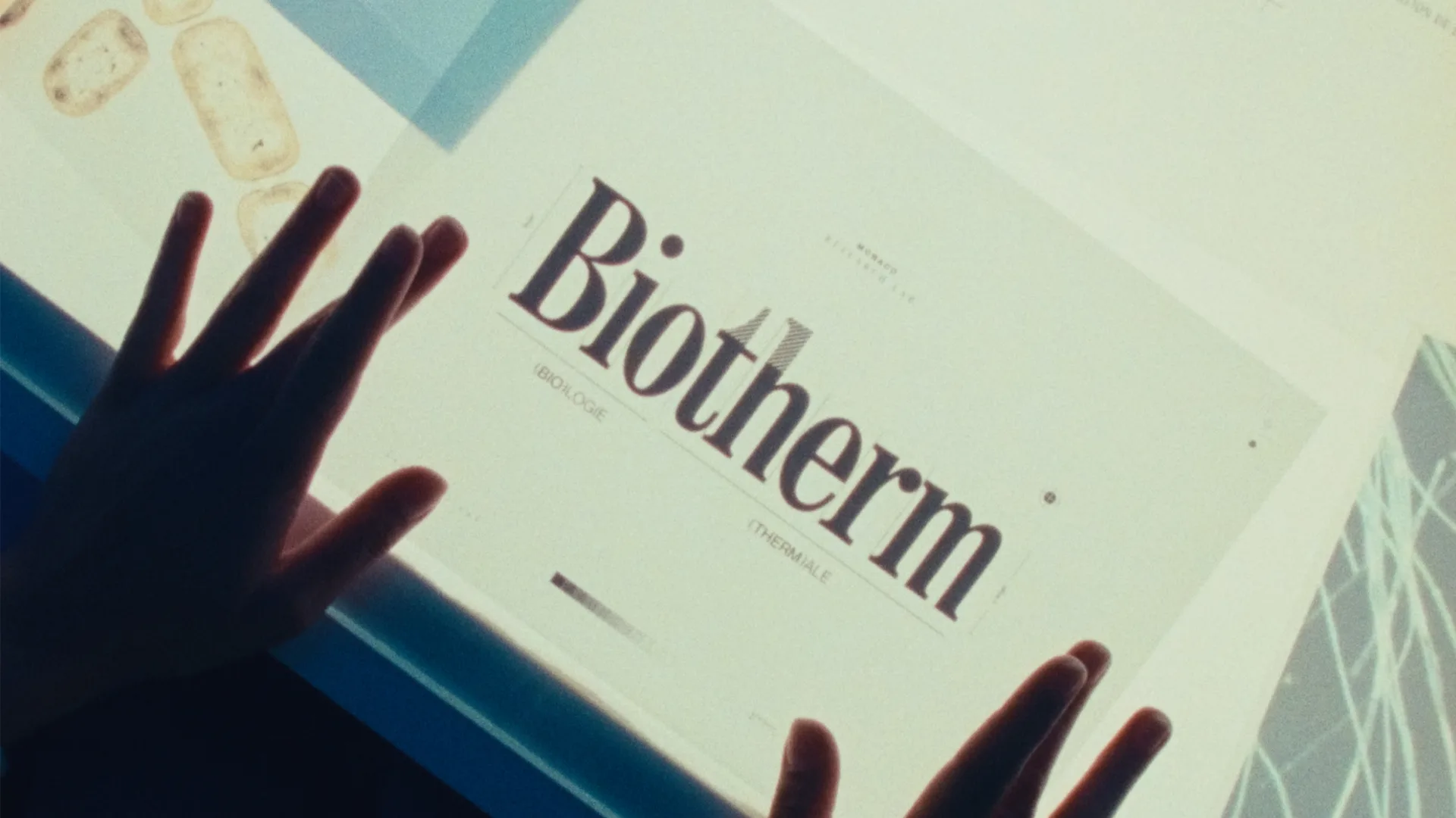 A pair of hands hovers over a backlit screen displaying the word Biotherm in large letters, with smaller text reading MOLECULAR and CYBERABLE.