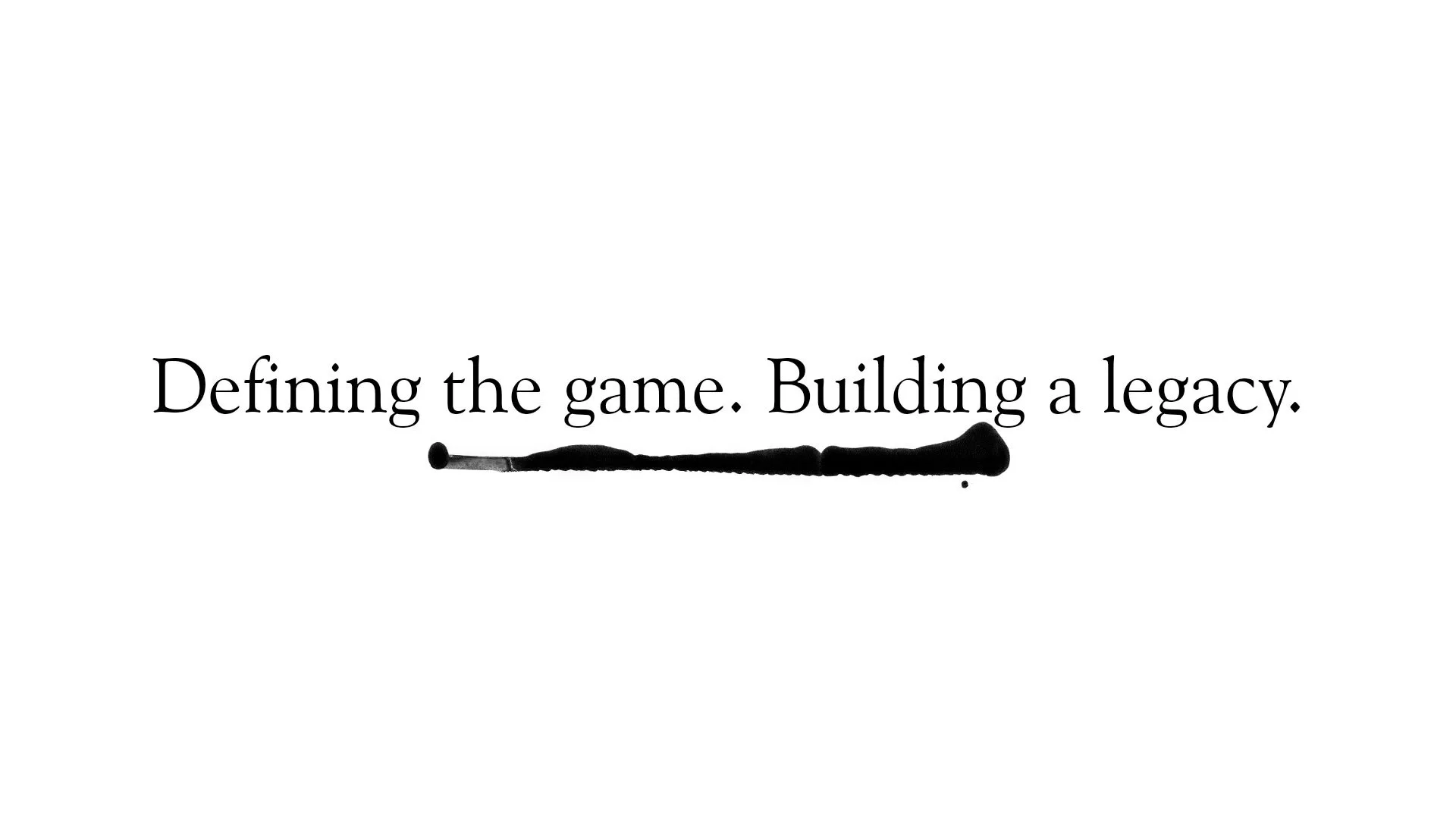 Text on a white background reads, Defining the game. Building a legacy. A thick black ink line runs underneath part of the text.