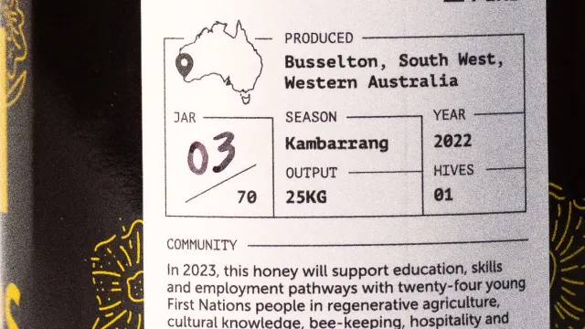 Close-up of a honey jar label showing location (Busselton, South West, Western Australia), season (Kambarang), year (2022), weight (250g), jar number (3 of 70), and support for First Nations community programs.