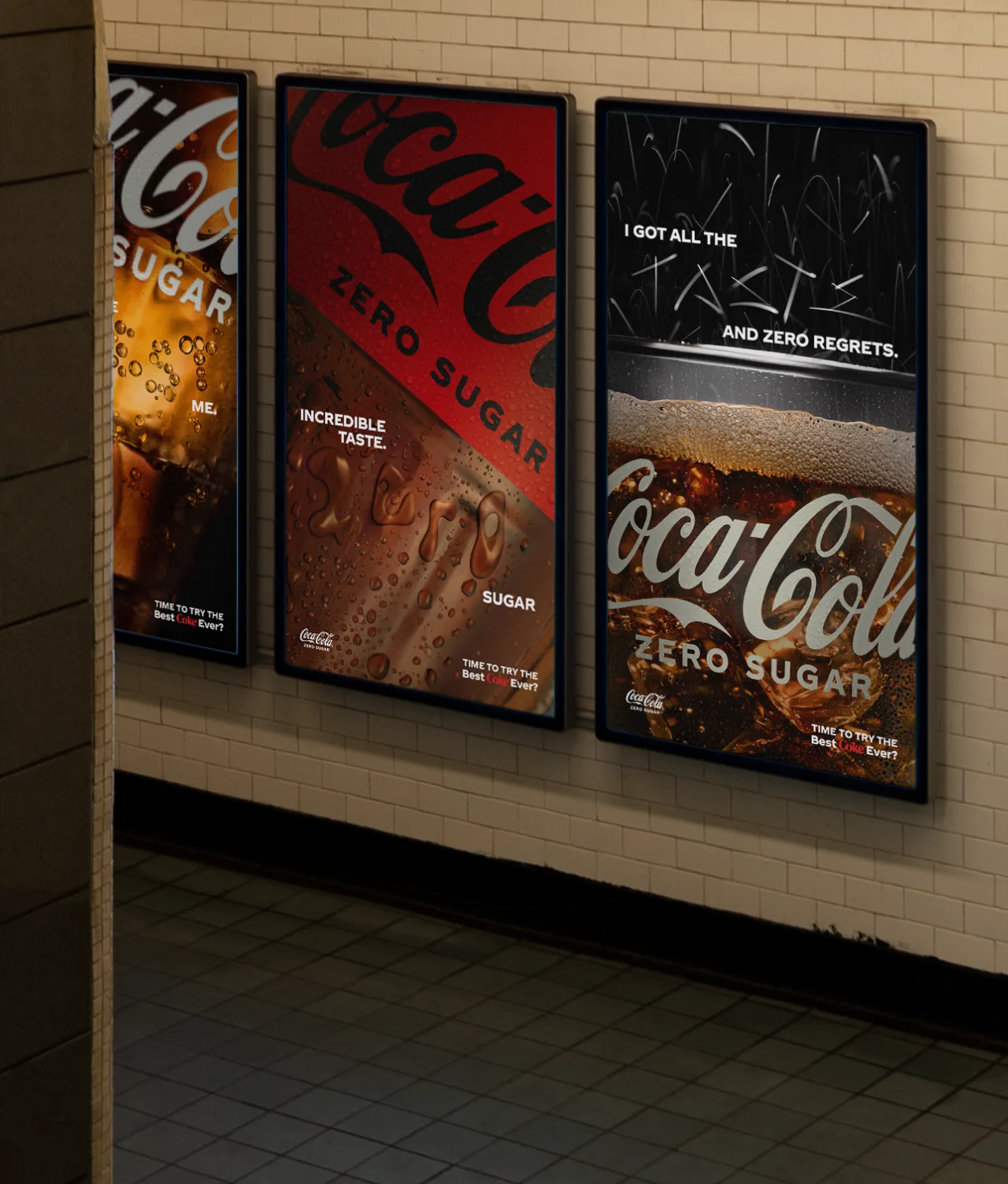 Three Coca-Cola Zero Sugar ads on a tiled subway wall, with close-up images of the drink and slogans like “Incredible taste,” “Zero sugar,” and “I got all the taste and zero regrets.”.