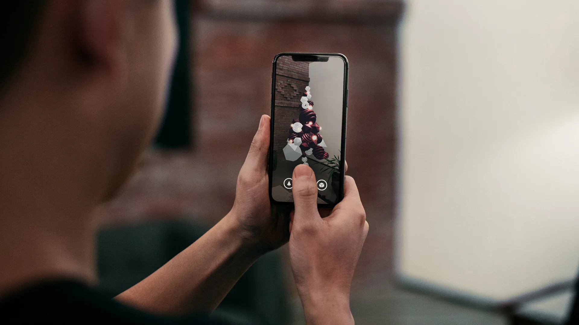 A person holds a smartphone and interacts with an augmented reality game displayed on the screen, featuring animated characters and objects overlaid onto the real environment.