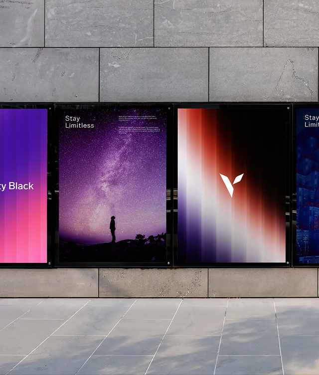 Three posters on a grey stone wall; the centre one shows a silhouette of a person looking up at a starry night sky with the words Stay Limitless, while the other two display abstract colourful designs.