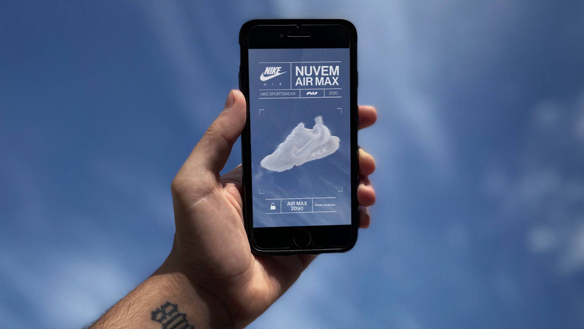 A hand holding a smartphone shows an app screen with a Nike Air Max sneaker made of clouds against a blue sky, with branding and product details in Portuguese. The sky and clouds are in the background.