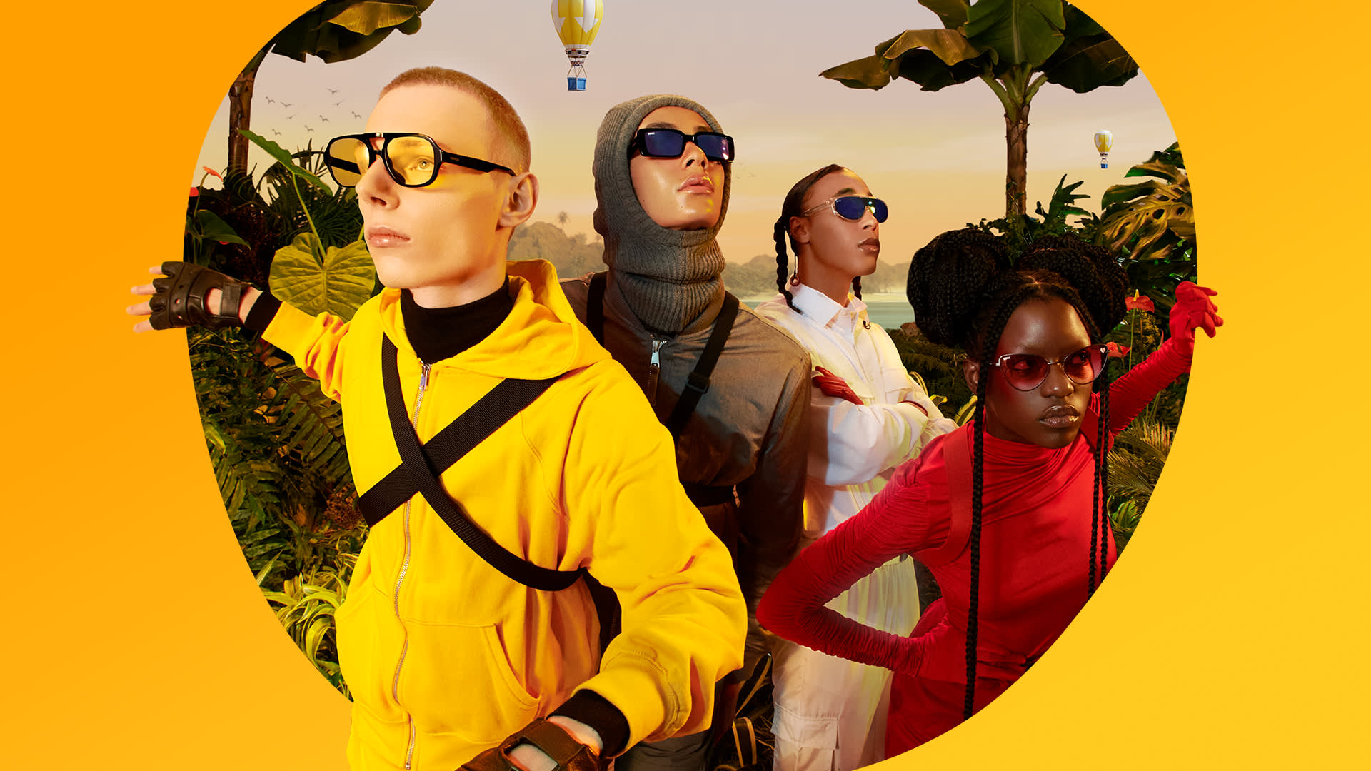 Four people in bold, colorful outfits and sunglasses pose confidently amid tropical plants, with a sunset sky and hot air balloon in the background, creating a vibrant, adventurous atmosphere.
