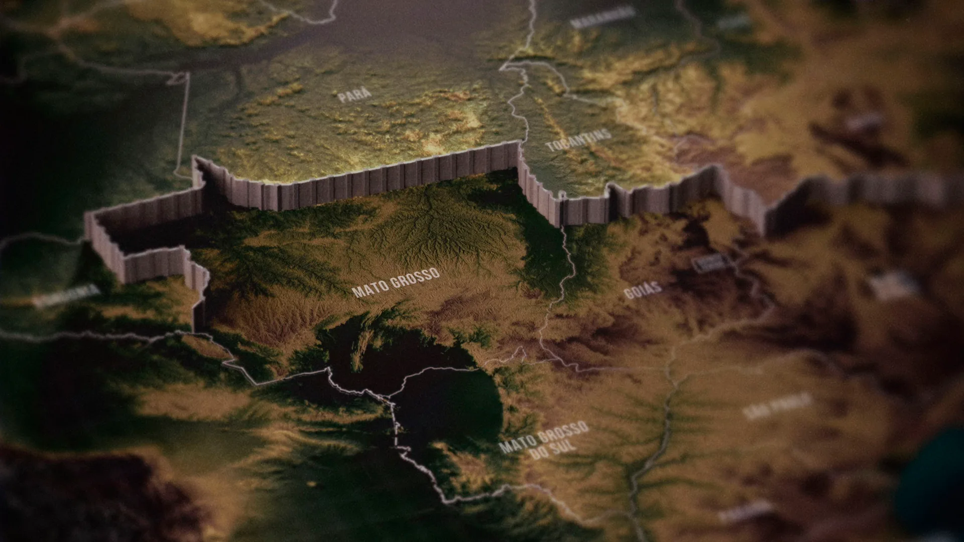 A close-up of a topographic map highlighting the Brazilian region of Mato Grosso with raised relief borders, showing neighboring regions like Pará, Tocantins, Goiás, and Mato Grosso do Sul.