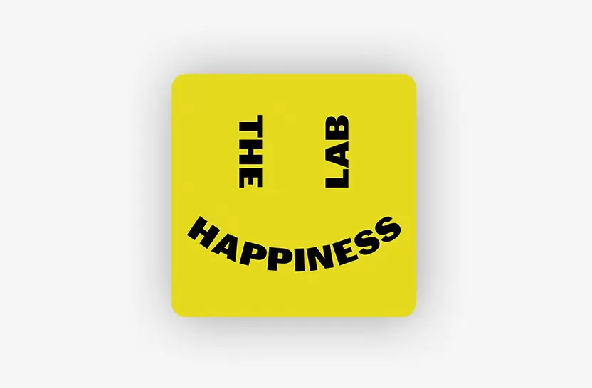 A yellow square with a smiley face made from black text: THE as the left eye, LAB as the right eye, and HAPPINESS curved as the smiling mouth. The background is light gray.