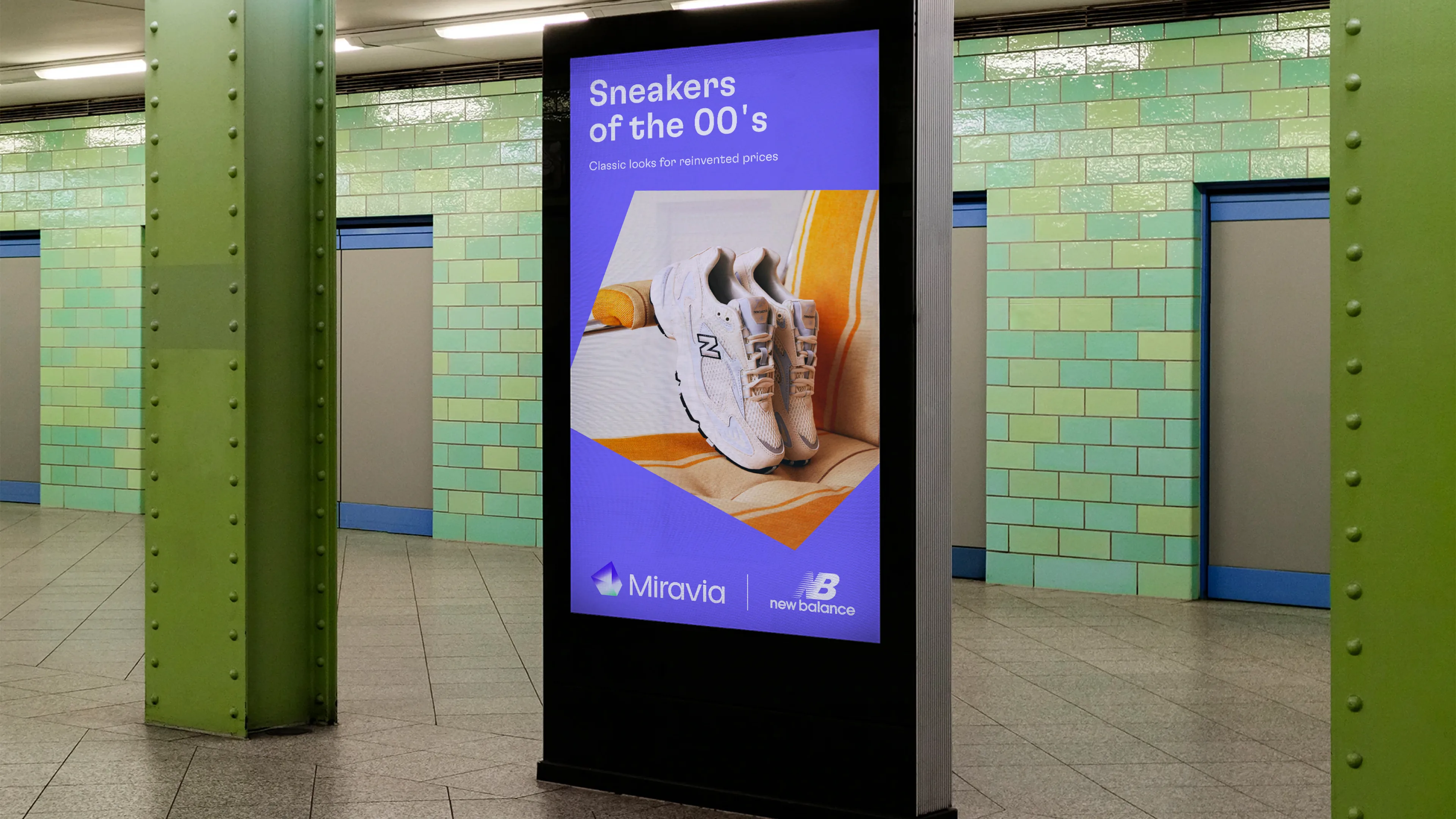 Digital advertisement in a subway station displays white New Balance sneakers, with the text “Sneakers of the 00’s, classic look for reinvented pros.” The background features green tiles and closed blue doors.