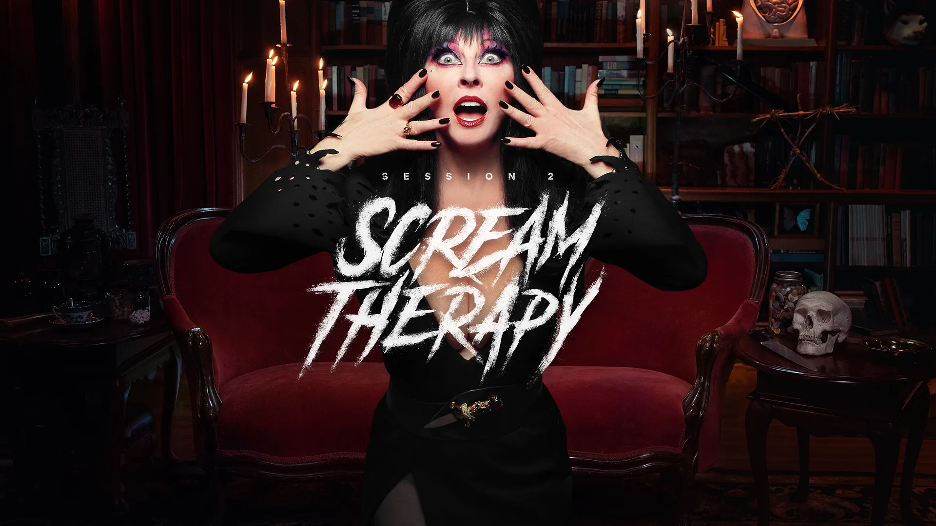 A woman dressed in gothic black clothing with dramatic makeup holds her hands near her face in a shocked expression. She stands in front of a red vintage sofa in a dimly lit, spooky room. Text reads Session 2 Scream Therapy.