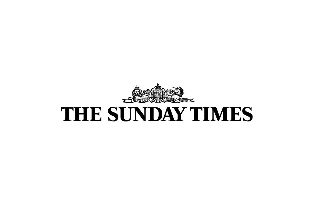 The logo of The Sunday Times newspaper, featuring black serif text and a detailed crest with crowns and lions above the title on a white background.