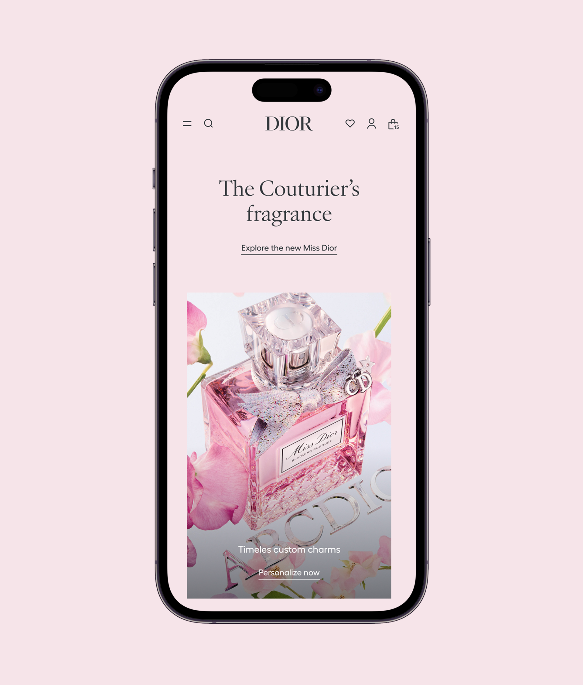 A smartphone displays Dior’s website featuring a pink Miss Dior perfume bottle surrounded by pink flowers, with text reading The Couturiers fragrance and options to explore and personalize.