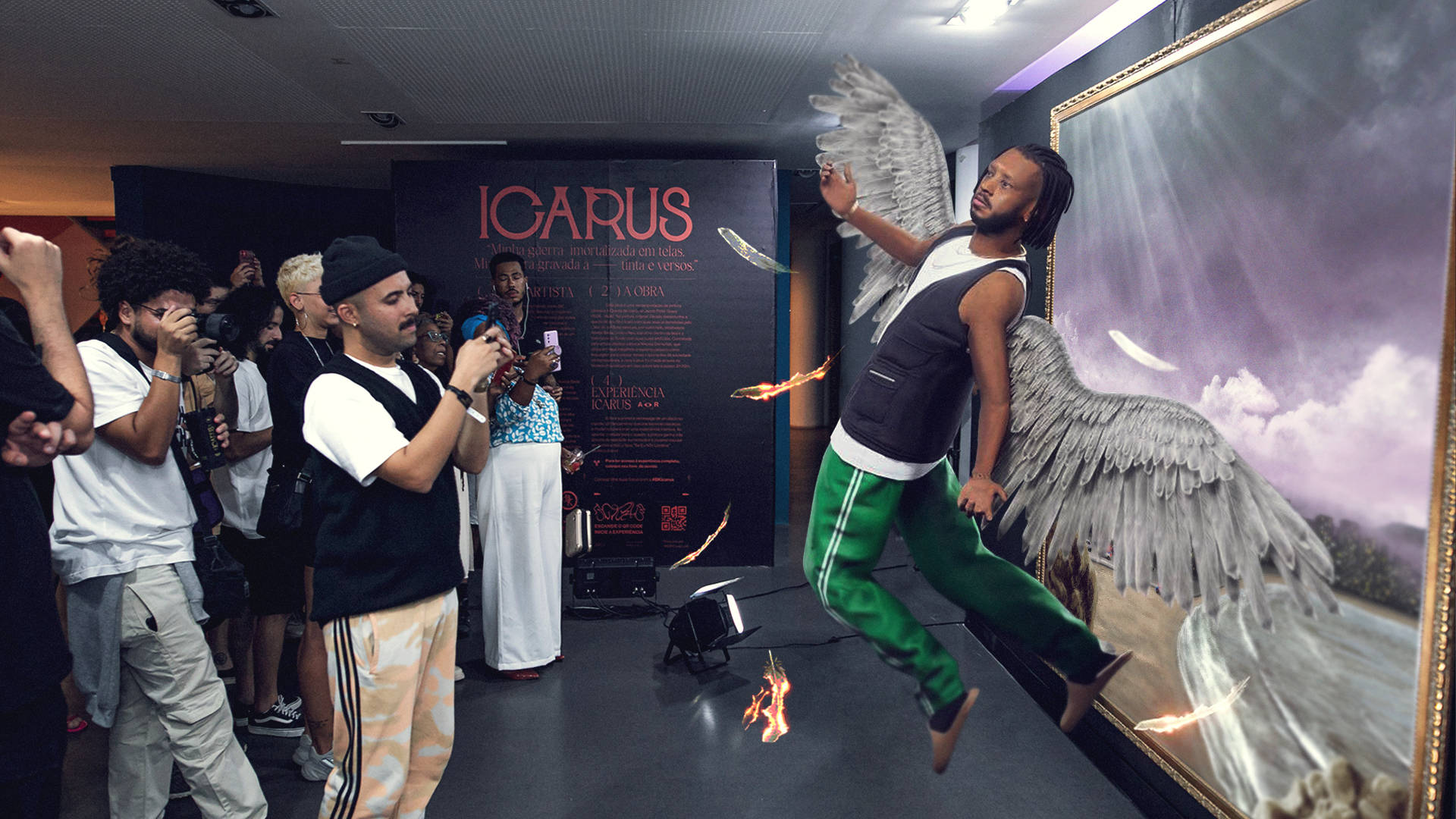 A man poses as if flying with angel wings in front of a large painting, surrounded by people taking photos. The scene is part of an art installation themed “ICARUS,” with some fiery visual effects near his feet.