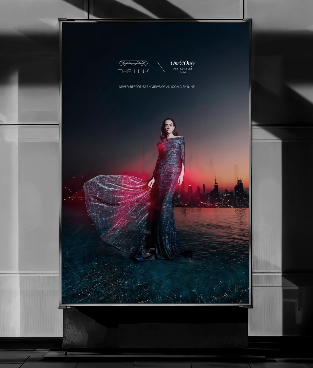 A woman in a shimmering gown stands in front of a city skyline at sunset, with the text “THE LINK” and “One&Only One Za’abeel” above her. The slogan reads, Never before seen view of an iconic skyline.