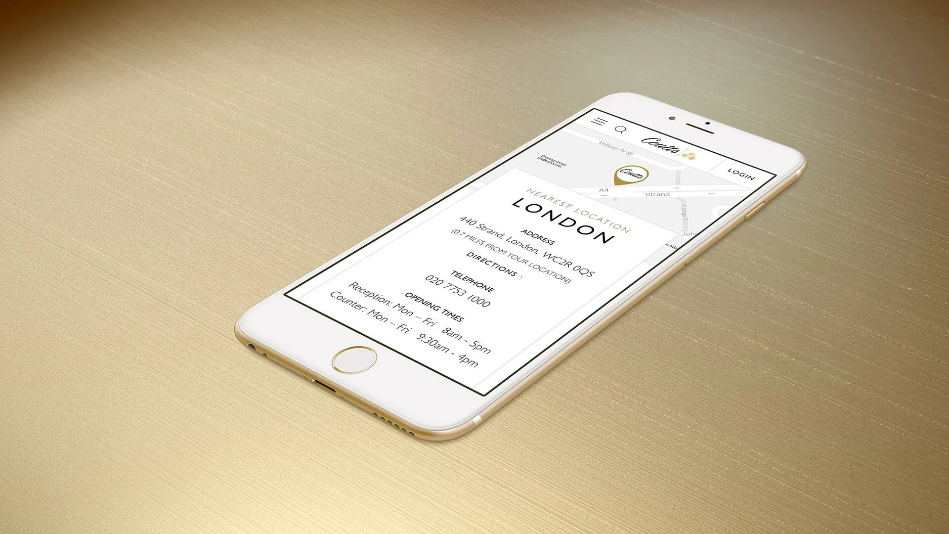 A smartphone displaying a location information page for London, including the address, phone number, opening hours, and a small map, resting on a gold-colored surface.
