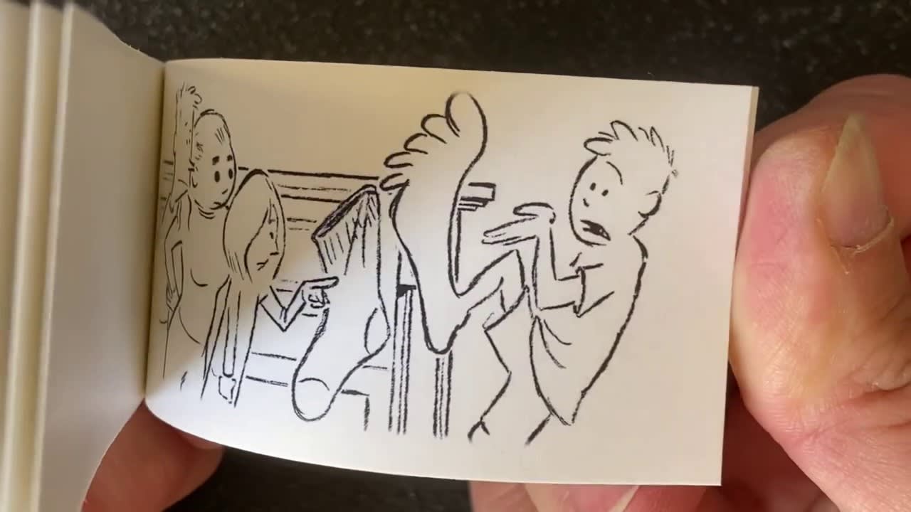 A hand holds a drawing showing a surprised boy recoiling from a large bare foot, while two other kids in the background react with shock and point at the foot.