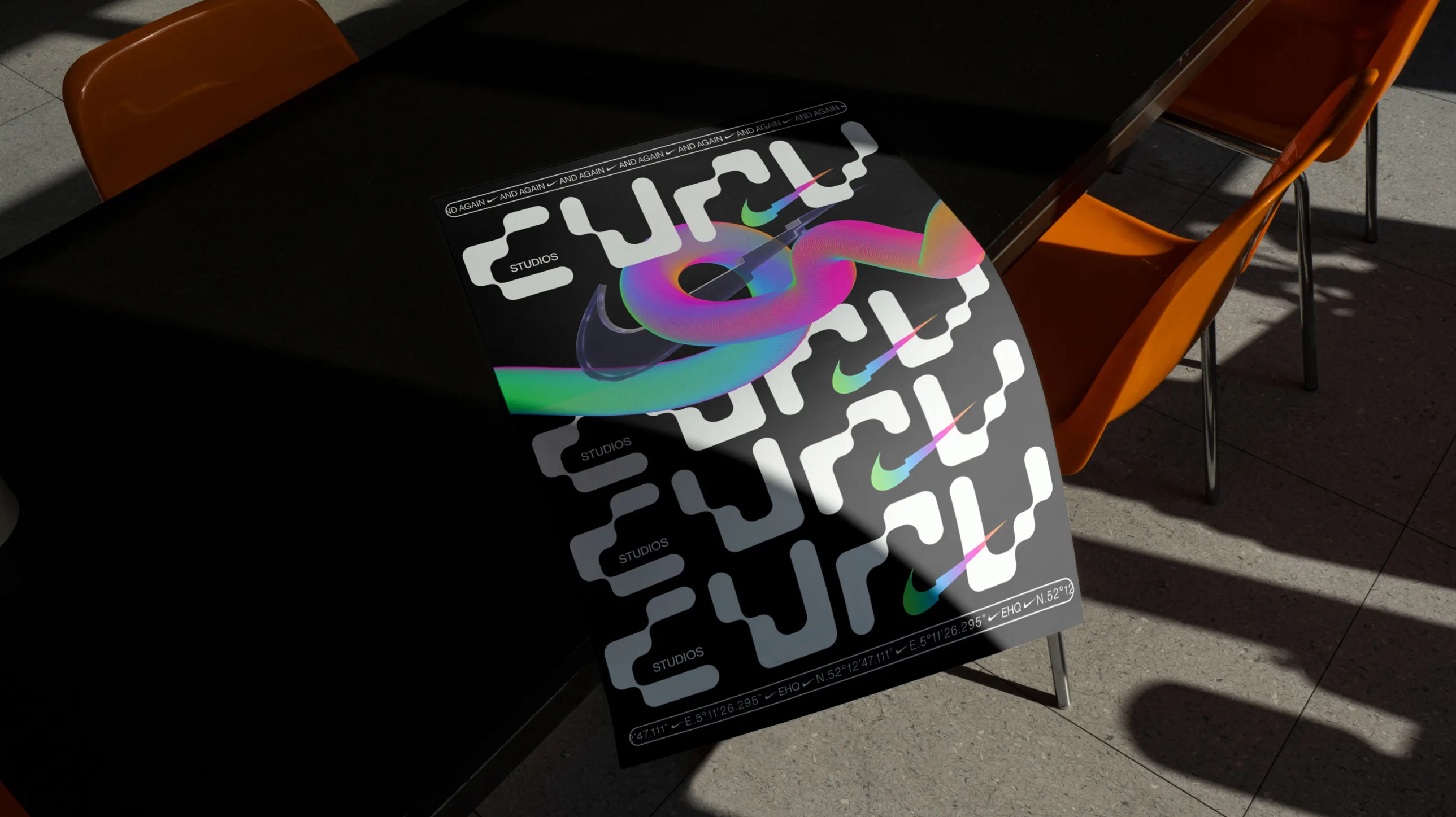 A colorful, abstract poster with futuristic designs and text is draped over the edge of a black table with orange chairs in a well-lit room.