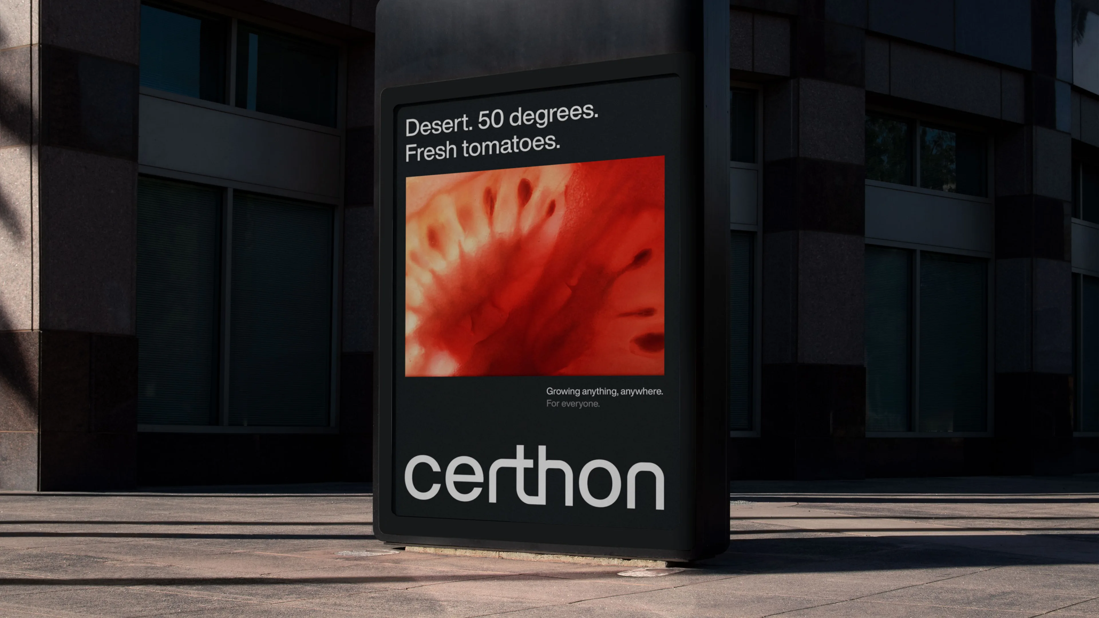 A sidewalk billboard displays a close-up image of a tomato with text above it reading, Desert. 50 degrees. Fresh tomatoes. Below the image, the logo certhon is prominently featured.