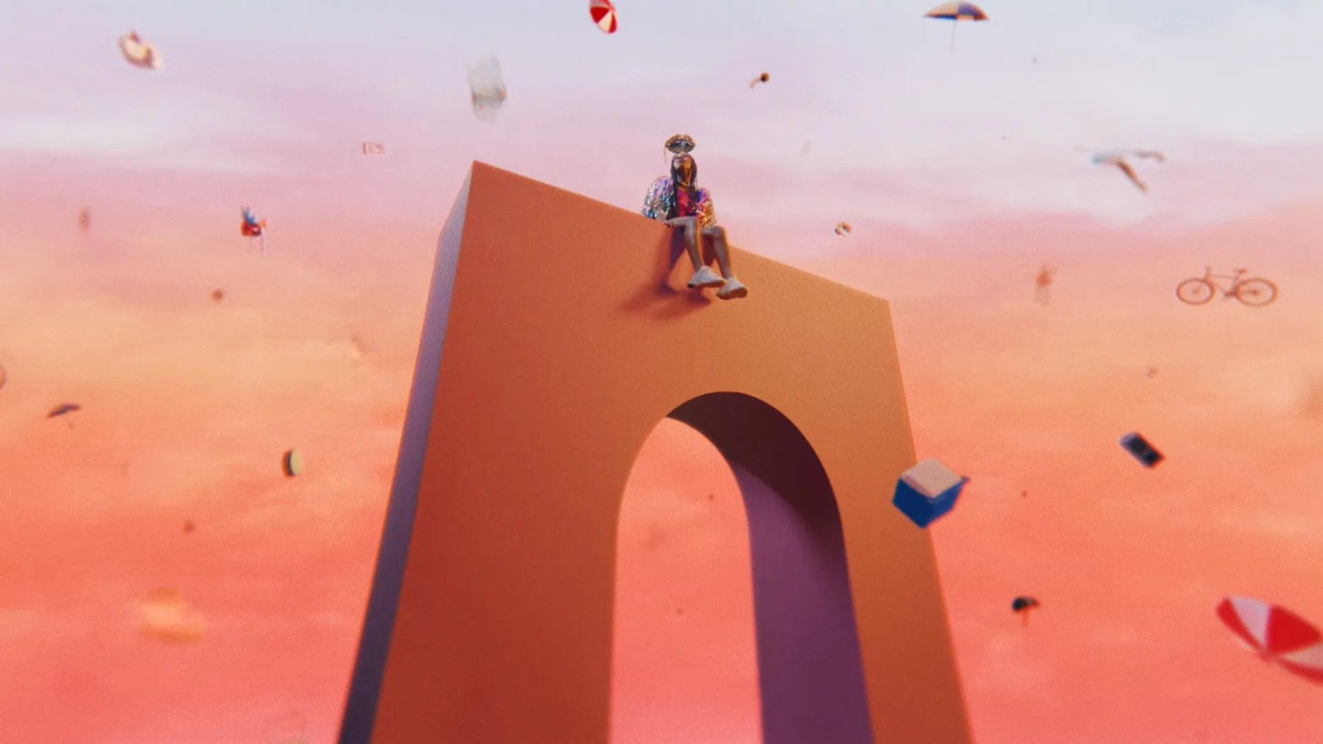 A person sits atop a large, stylized peach-colored arch against a pink sky, surrounded by floating objects like umbrellas, books, and a bicycle. The scene has a surreal, dreamlike atmosphere.