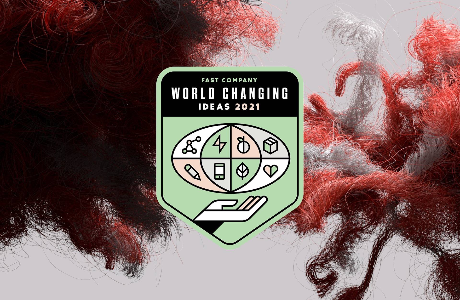 A badge reading “Fast Company World Changing Ideas 2021” appears over a swirling background of red, black, and white fibers, with icons representing science, energy, health, money, and nature above an open hand.