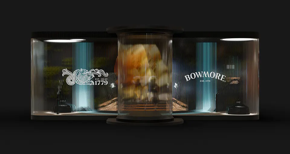 A sleek, illuminated display booth with transparent curved panels featuring the Bowmore logo and Est. 1779, along with decorative graphics, surrounds a central cylindrical case with a blurred object inside.