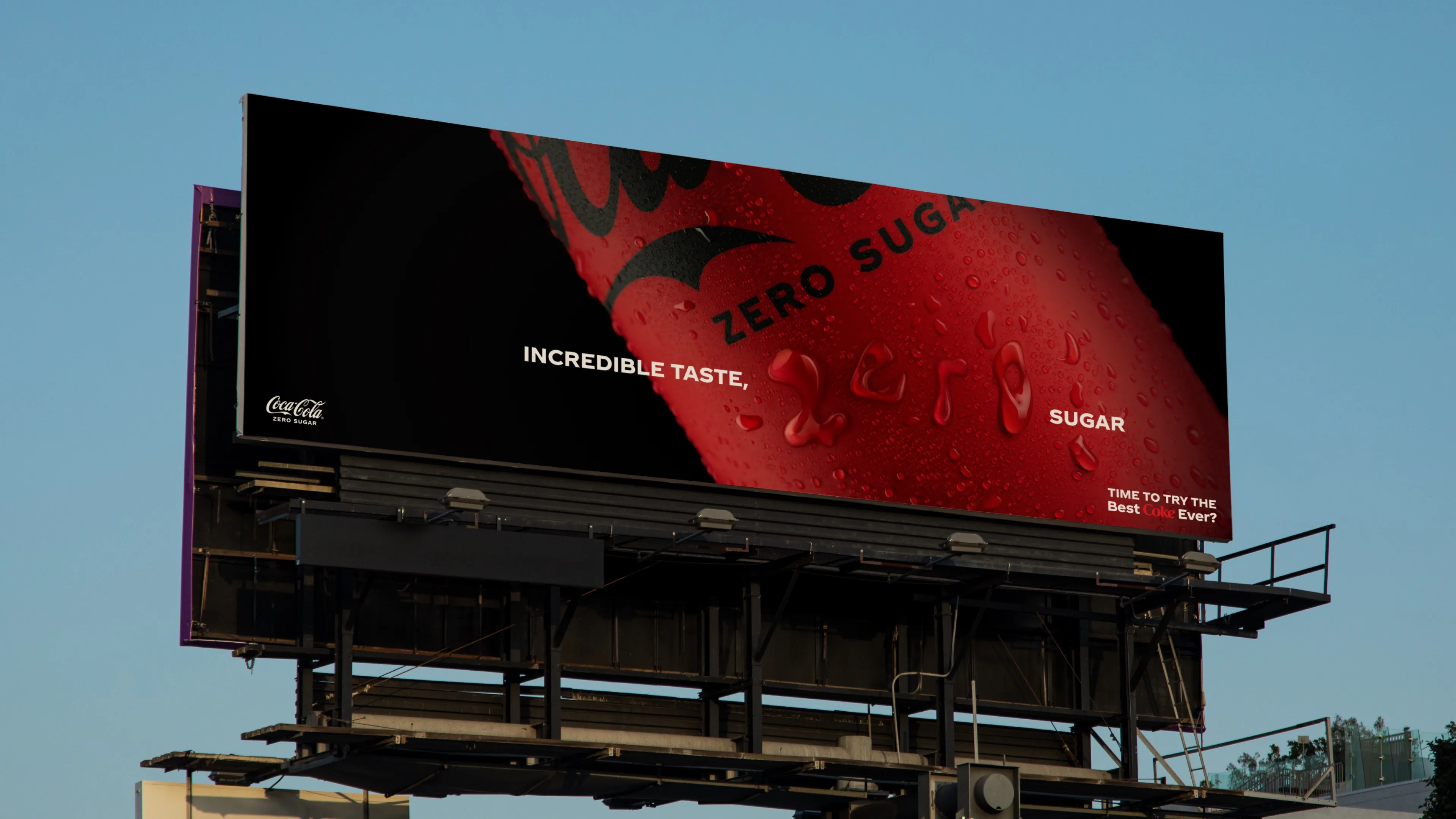 A billboard advertising Coca-Cola Zero Sugar, featuring a close-up of a red can with water droplets. The text reads: INCREDIBLE TASTE, ZERO SUGAR and TIME TO TRY THE BEST EVER? against a blue sky.