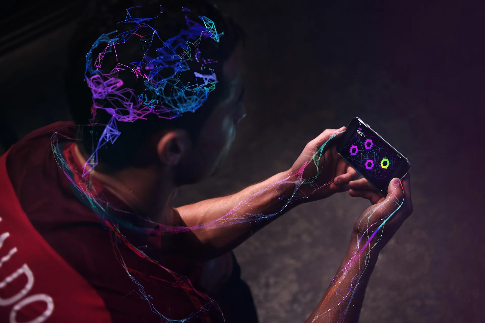 A person in a sports jersey plays a mobile game, with colorful digital lines and neural patterns connecting their head and arm, symbolizing brain activity and connectivity.