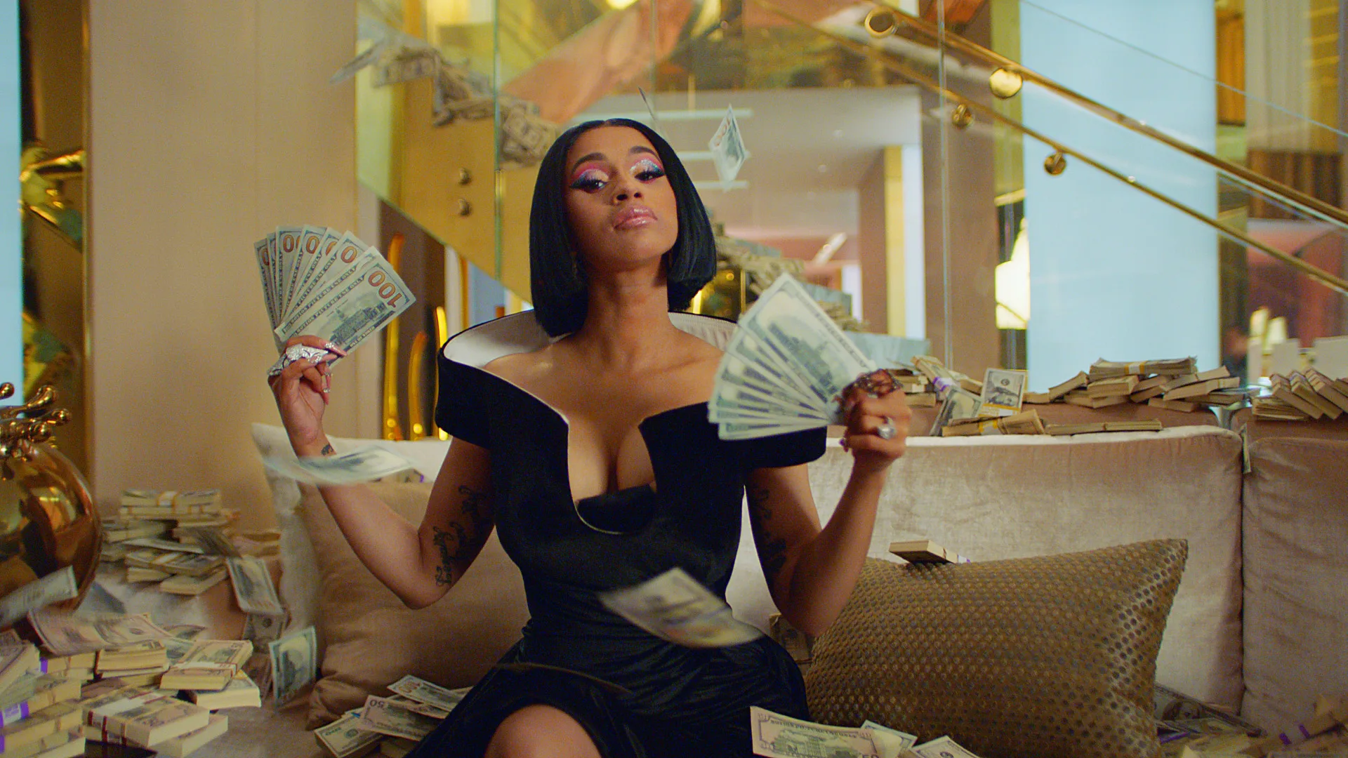A woman in a black dress sits on a couch, holding and fanning out stacks of cash in both hands, with piles of money around her and more bills falling in the air. The setting is luxurious with gold accents.