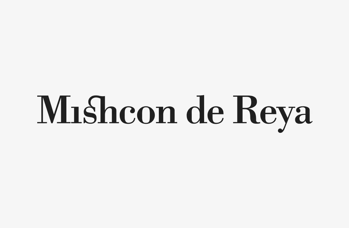Black text reading Mishcon de Reya in a serif font on a light gray background. The lowercase h in Mishcon is stylized with a unique double-stem design.