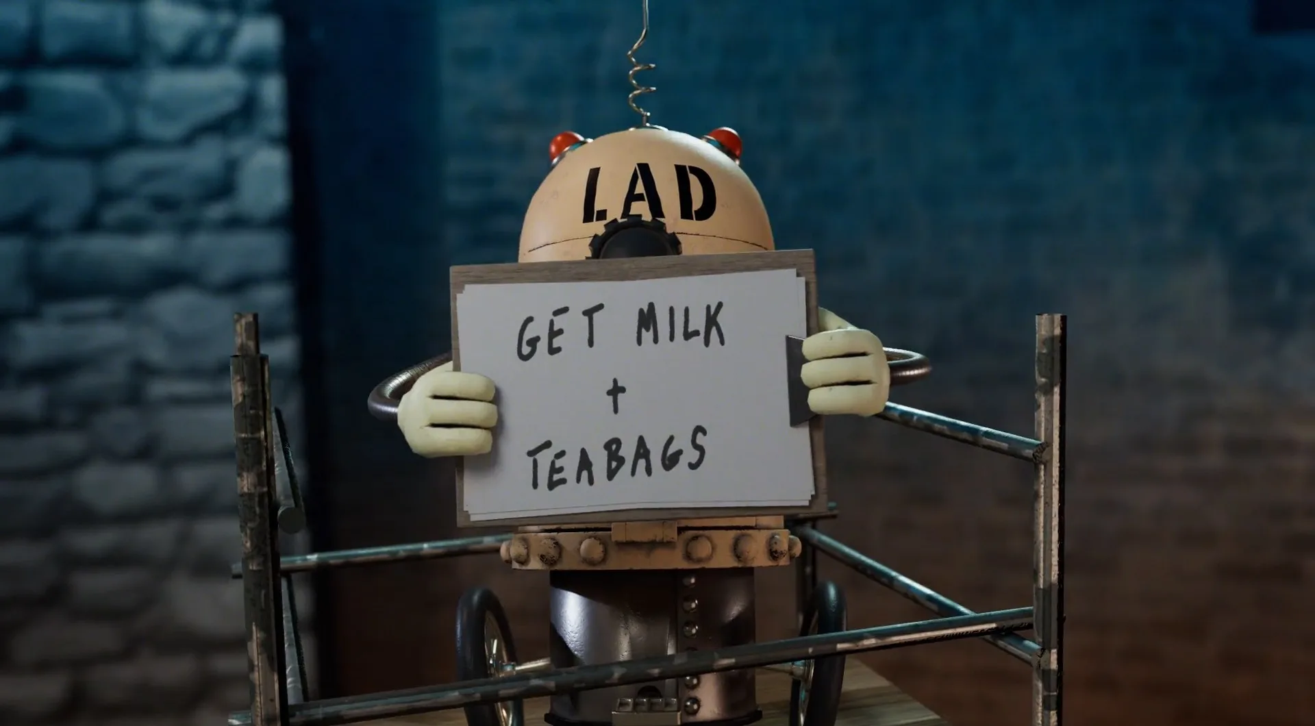A small robot with LAD on its head holds a sign that reads GET MILK + TEABAGS while standing behind metal railings in a dimly lit room.