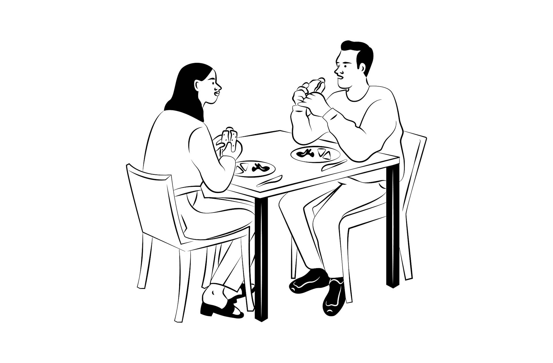 A man and a woman are sitting at a table, facing each other and eating sandwiches. Plates with food are on the table. Both appear to be engaged in conversation.