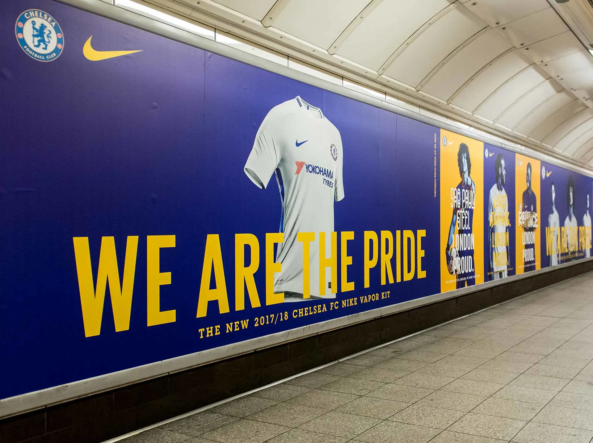 An advertisement in a subway station displays a blue and yellow Chelsea FC banner with a white jersey and the slogan “WE ARE THE PRIDE” promoting the 2017/18 Nike Vapor kit.