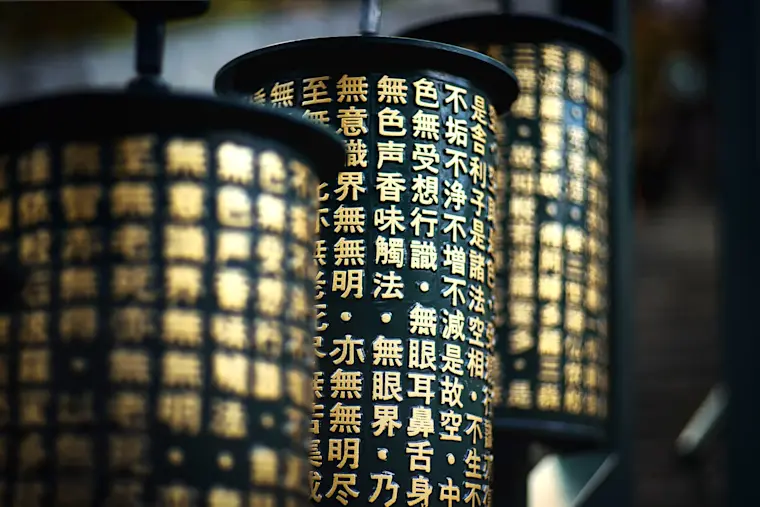 Zwarte gebedsmolens of cilinders met gouden Chinese/Boeddhistische karakters.
