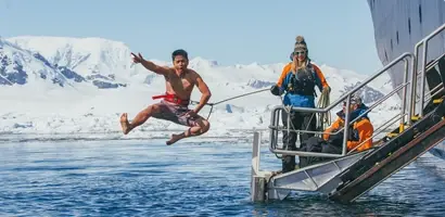 man-springt-in-poolwater-van-boot